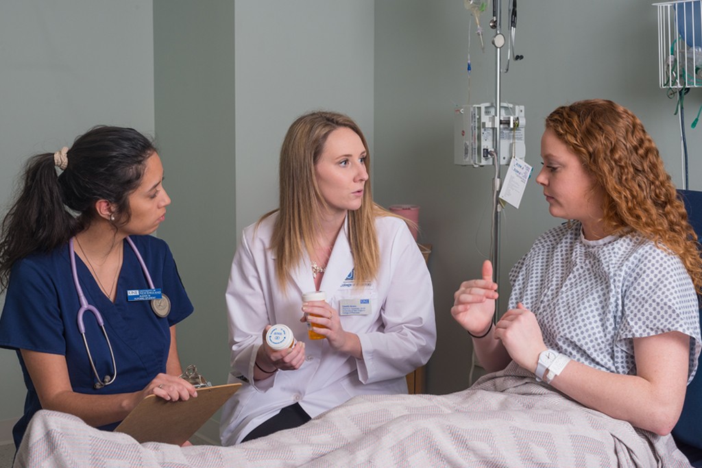 A nursing student and a pharmacy student practicing speaking with a patient