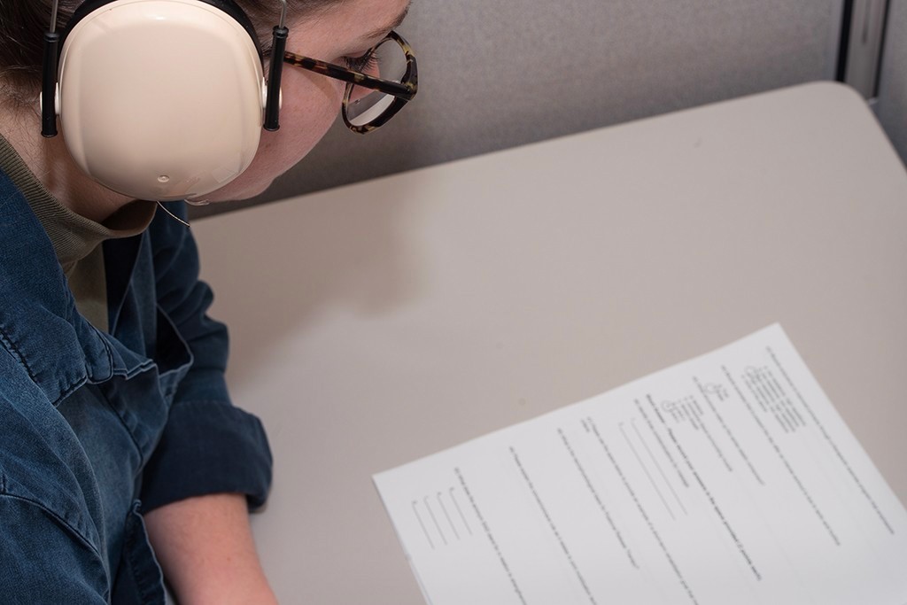 A student wears over-the-ear headphones while taking a test