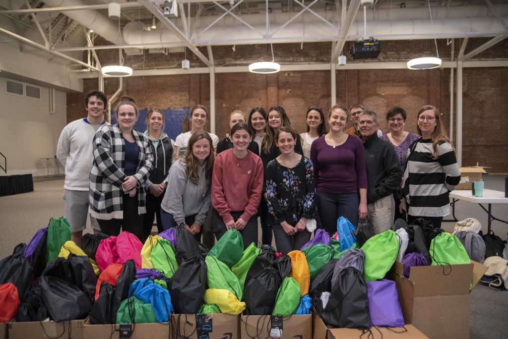 A group of students pose together for a Service-Learning program where they prepared harm-reduction bags for the Maine Correctional Facility