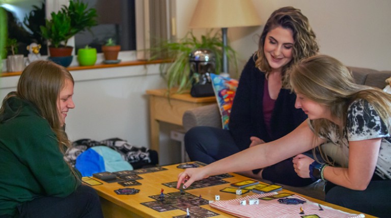 Students playing a board game in their dorm room