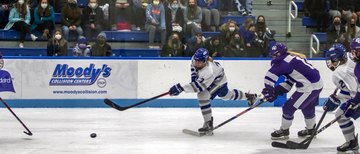 Women's hockey players going after the puck during a game
