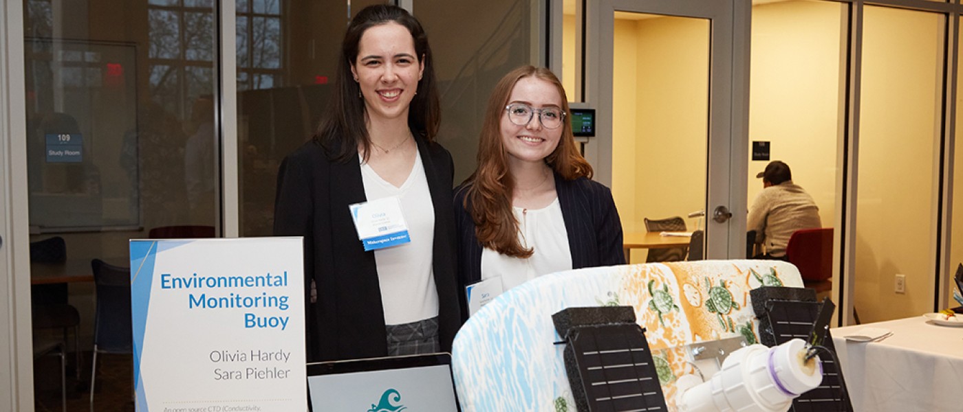 Two U N E students showing their project at the Innovation Challenge