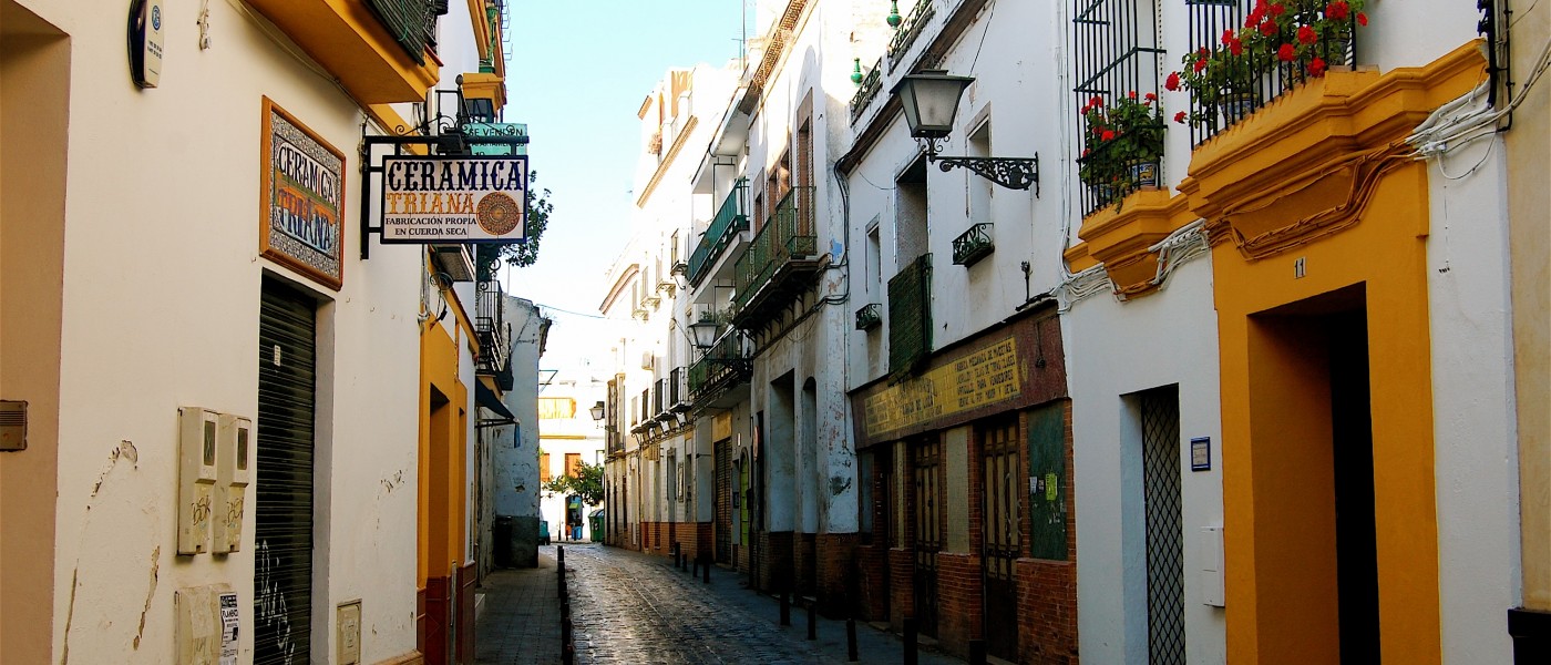 Colorful stucco buildings line narrow Callej贸n Sevillano in Seville 