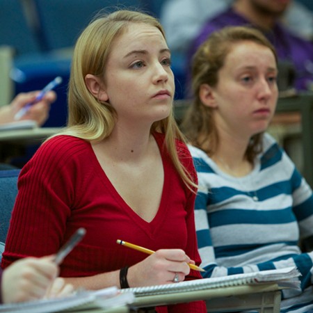 a student takes notes during a lecture