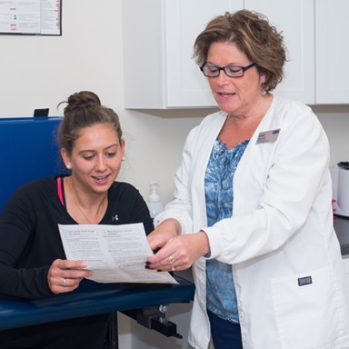 A student going over health paperwork with a U N E nurse