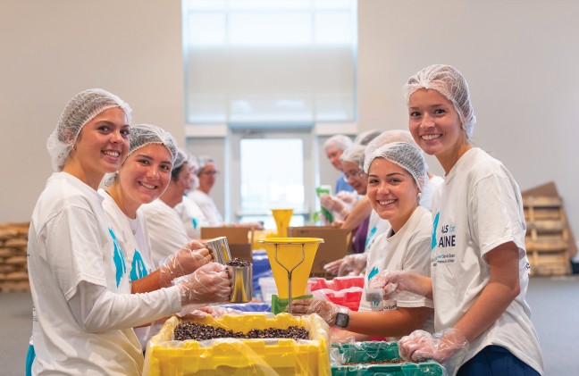 A group of students pack rice and beans for the Meals for Maine event