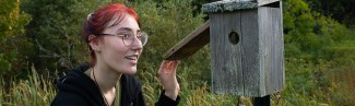 A student checks a bird house